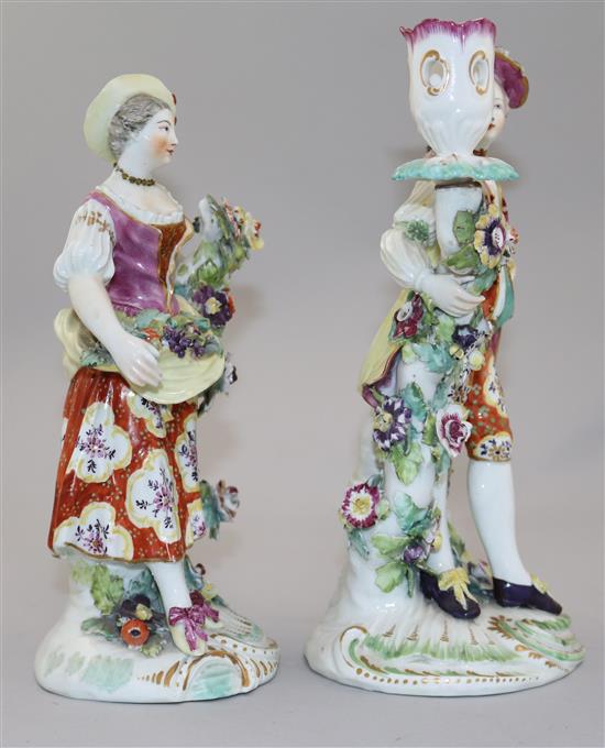 A pair of Derby candlestick figures of a gentleman and a lady, 24cm, damaged